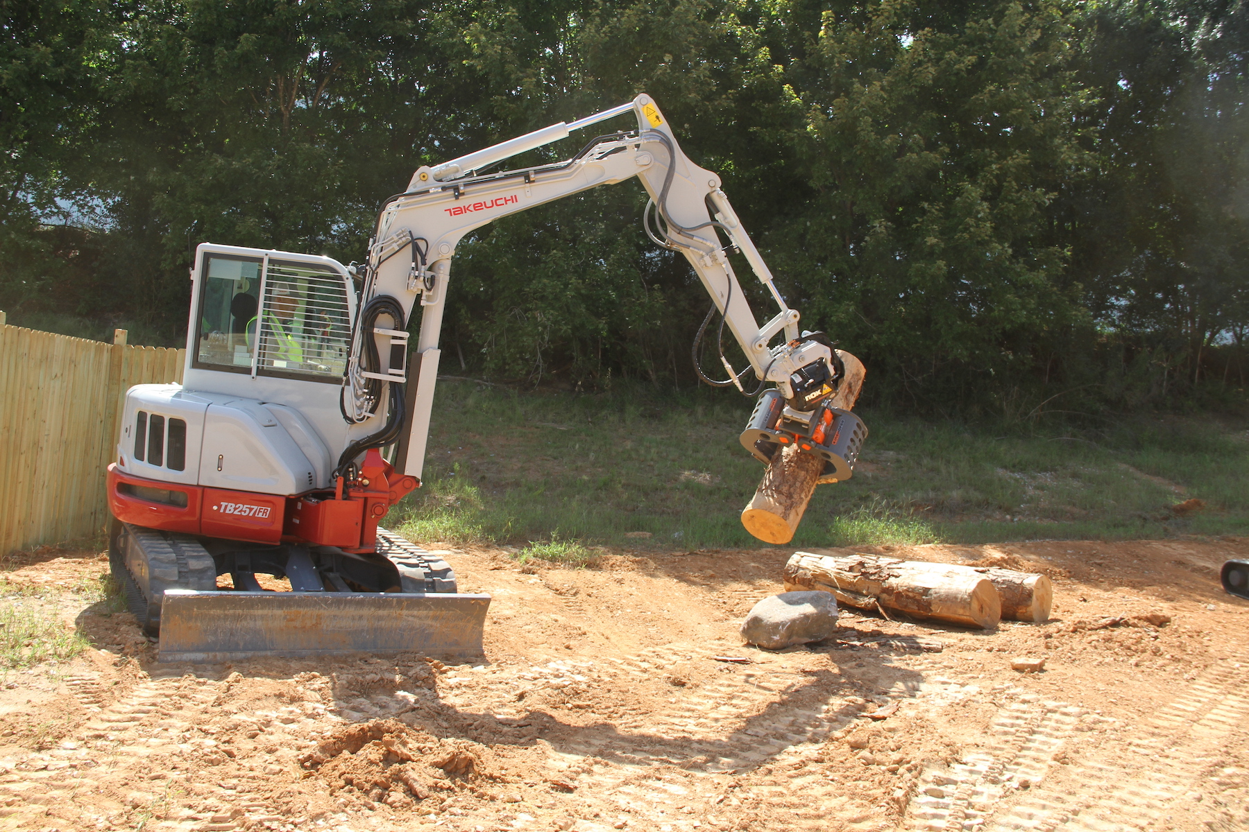 Takeuchi Tiltrotator excavator attachment grabbing log